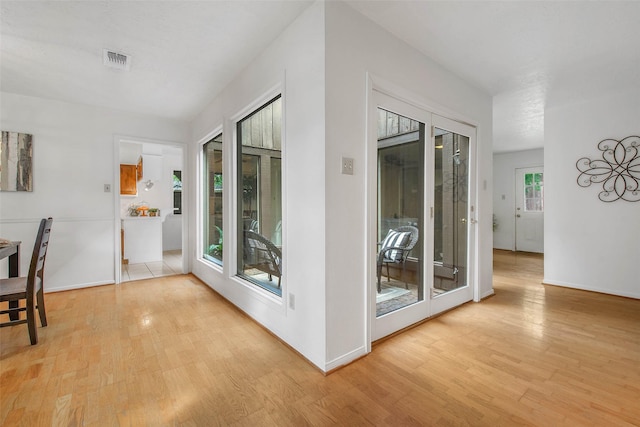 doorway to outside with visible vents, baseboards, and wood finished floors