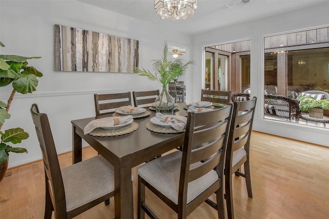 dining room with an inviting chandelier, wood finished floors, and visible vents