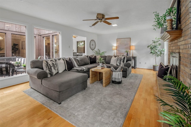living area with ceiling fan, wood finished floors, and a fireplace