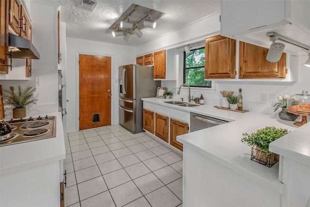 kitchen featuring visible vents, appliances with stainless steel finishes, a sink, light countertops, and under cabinet range hood