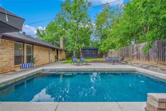 view of pool featuring a fenced in pool, an outdoor structure, a fenced backyard, a shed, and a patio