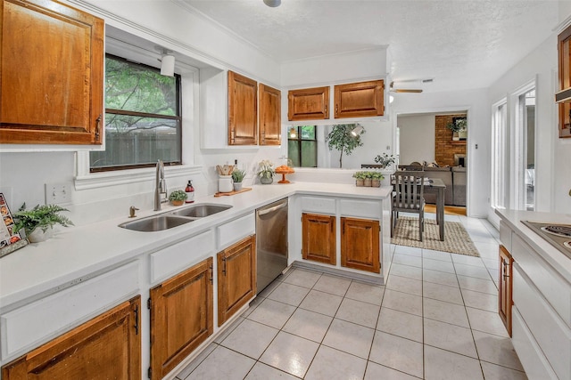 kitchen with a sink, light countertops, brown cabinetry, and stainless steel appliances