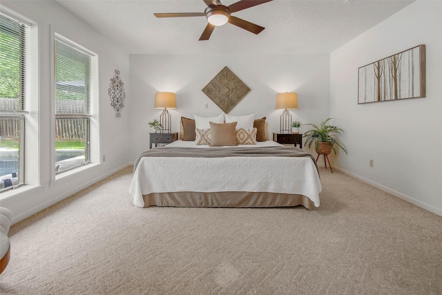 bedroom with baseboards, light carpet, and a ceiling fan