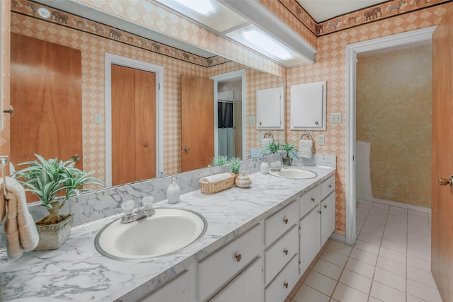 full bath with a sink, tile patterned floors, and wallpapered walls