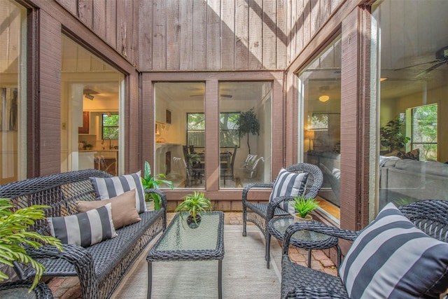 sunroom with a ceiling fan and an outdoor hangout area