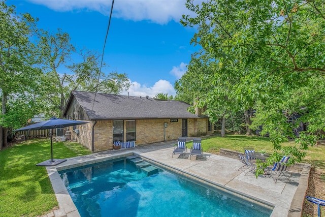 pool featuring a lawn, fence, and a patio area