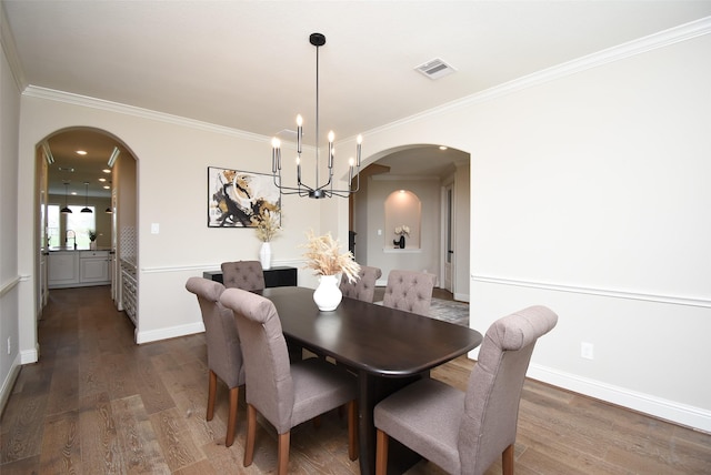 19019 Kimber Creek Ln, Cypress, TX 77429 - dining room featuring arched walkways, ornamental molding, dark wood-style floors, a chandelier, and baseboards