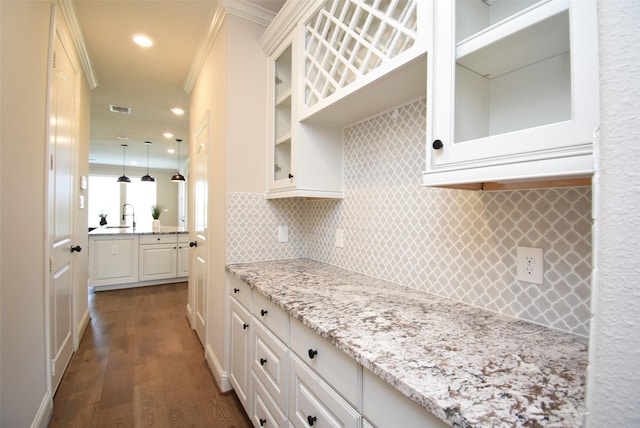 19019 Kimber Creek Ln, Cypress, TX 77429 - kitchen with dark wood-type flooring, decorative backsplash, white cabinets, light stone countertops, and a sink