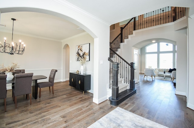 19019 Kimber Creek Ln, Cypress, TX 77429 - dining area featuring stairs, wood finished floors, arched walkways, a chandelier, and crown molding