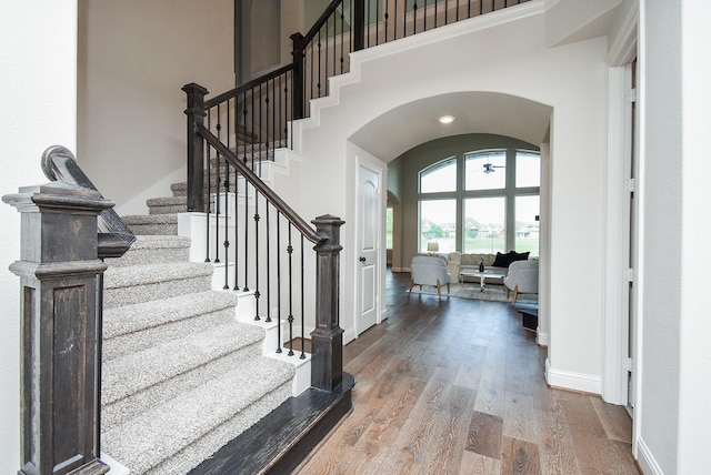 19019 Kimber Creek Ln, Cypress, TX 77429 - entryway with arched walkways, wood finished floors, stairway, a high ceiling, and baseboards