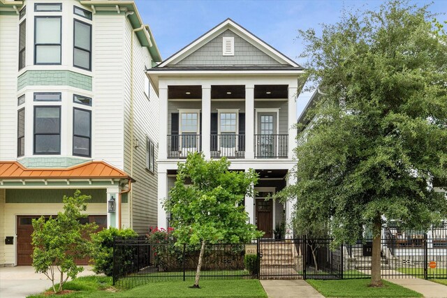 view of front of property featuring a garage, a fenced front yard, and a balcony