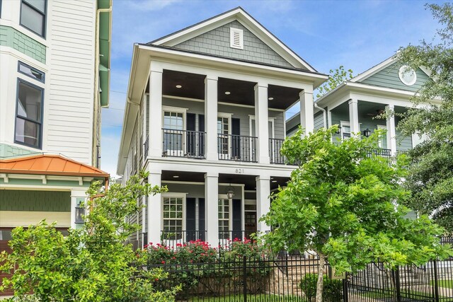 view of front of home featuring fence and a balcony