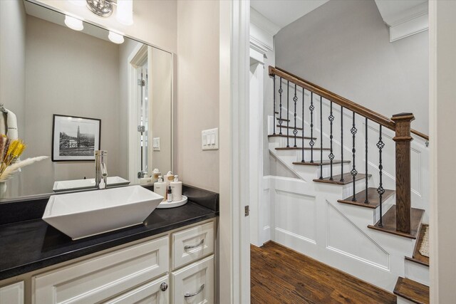 bar featuring a sink, stairway, and dark wood-style floors