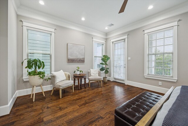 sitting room featuring crown molding, plenty of natural light, a ceiling fan, wood finished floors, and visible vents