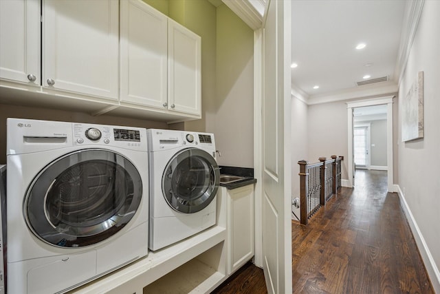 washroom featuring cabinet space, dark wood-style flooring, crown molding, visible vents, and washing machine and dryer