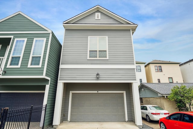 view of front of property featuring a garage and fence
