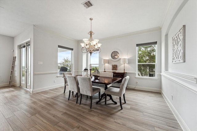 dining area featuring visible vents, crown molding, a chandelier, and light wood-type flooring