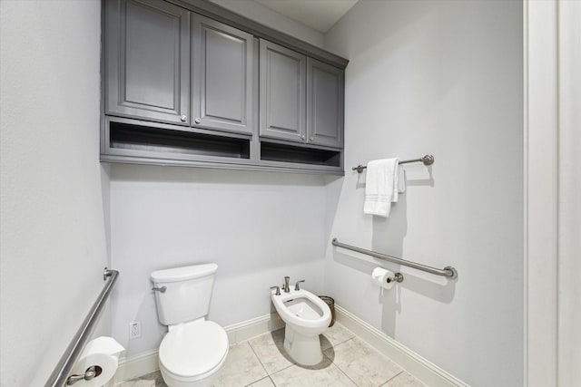 half bathroom with baseboards, a bidet, and toilet