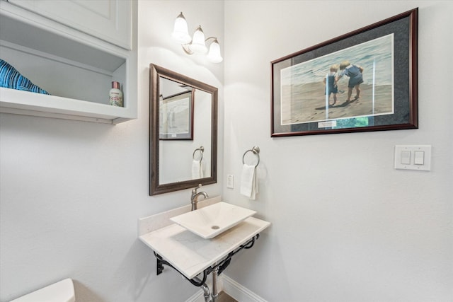 bathroom featuring a sink, baseboards, and toilet