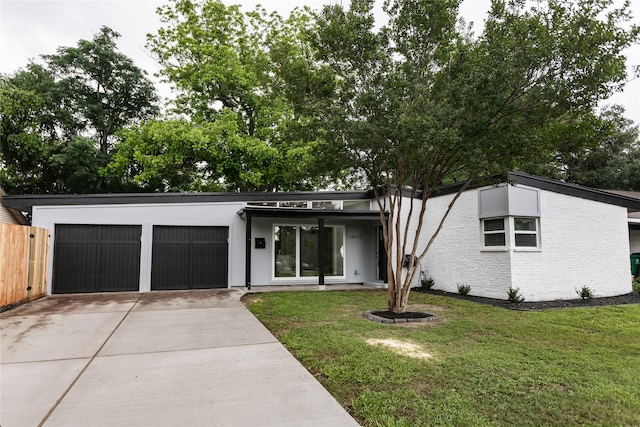mid-century inspired home featuring an attached garage, concrete driveway, stucco siding, and a front lawn