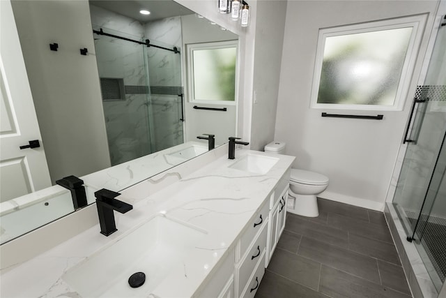 bathroom featuring a sink, a marble finish shower, and baseboards