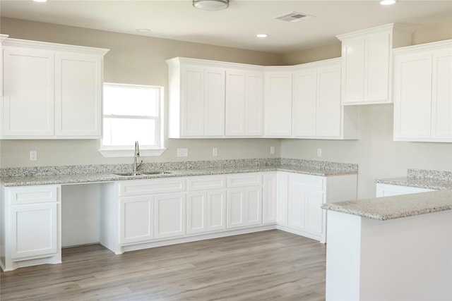 528 Thunder Rd, Surfside Beach, TX 77541 - kitchen featuring recessed lighting, light stone countertops, white cabinets, and light wood-type flooring
