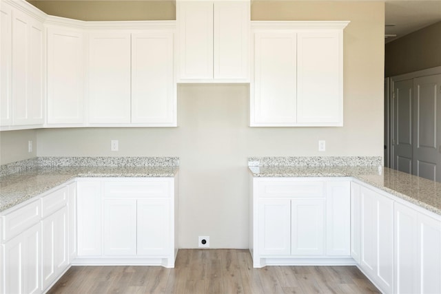 528 Thunder Rd, Surfside Beach, TX 77541 - kitchen featuring light stone counters, light wood-style flooring, and white cabinets