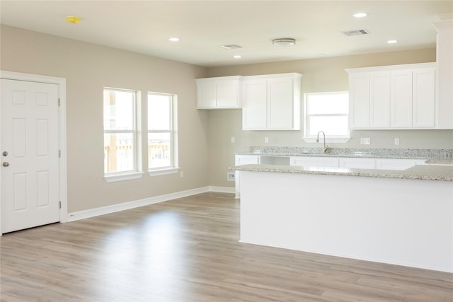 528 Thunder Rd, Surfside Beach, TX 77541 - kitchen featuring white cabinetry, light stone countertops, light wood-type flooring, and recessed lighting