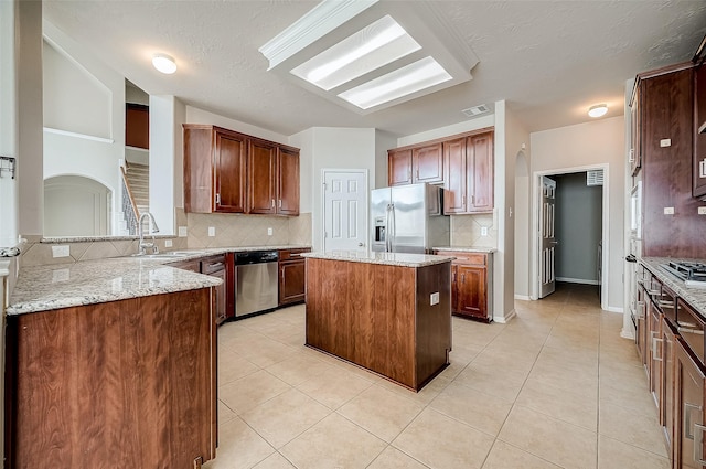 17931 Oakfield Glen Ln, Cypress, TX 77433 - kitchen with a center island, tasteful backsplash, a sink, light tile patterned floors, and stainless steel appliances