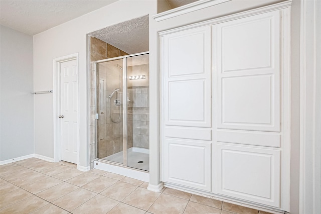 17931 Oakfield Glen Ln, Cypress, TX 77433 - full bathroom with baseboards, a stall shower, a textured ceiling, and tile patterned floors