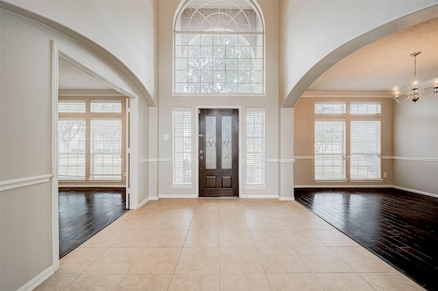 17931 Oakfield Glen Ln, Cypress, TX 77433 - tiled entryway with arched walkways, baseboards, a high ceiling, and a chandelier