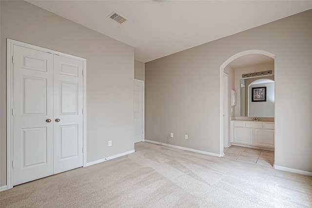 17931 Oakfield Glen Ln, Cypress, TX 77433 - unfurnished bedroom with arched walkways, baseboards, light carpet, and visible vents