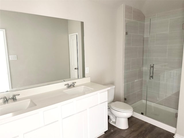 1563 Belton Ln, Anahuac, TX 77514 - bathroom featuring double vanity, a stall shower, toilet, and wood finished floors