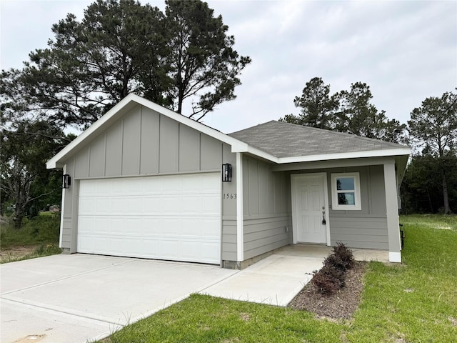 1563 Belton Ln, Anahuac, TX 77514 - ranch-style home with an attached garage, a shingled roof, driveway, board and batten siding, and a front lawn