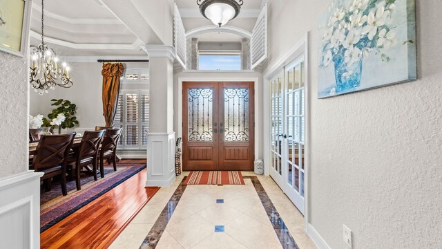 12722 Longmire Way, Conroe, TX 77304 - foyer featuring a chandelier, healthy amount of natural light, ornamental molding, french doors, and a textured wall