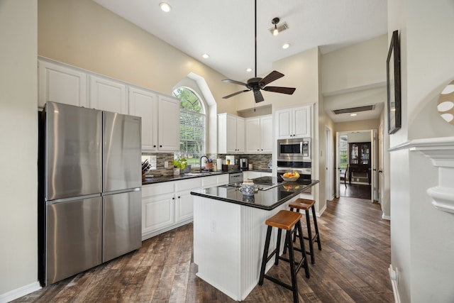 kitchen with dark countertops, appliances with stainless steel finishes, white cabinetry, and visible vents