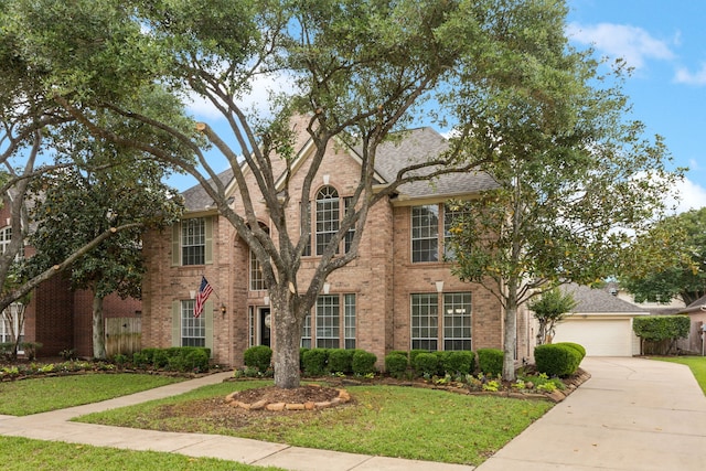 view of front facade with fence, a front yard, driveway, and brick siding