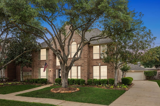 view of front of home with fence, an attached garage, a front lawn, brick siding, and concrete driveway