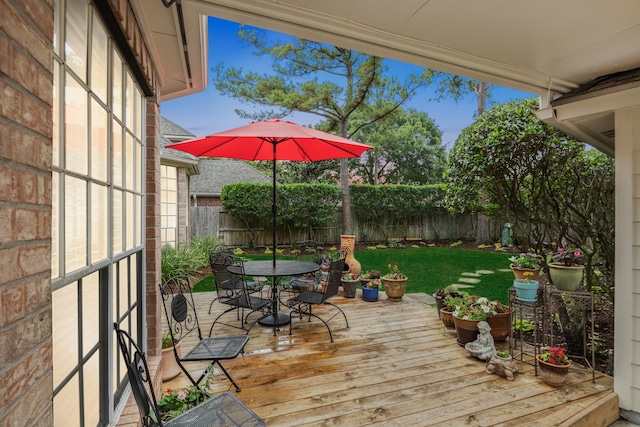 wooden terrace featuring a yard, a fenced backyard, and outdoor dining space