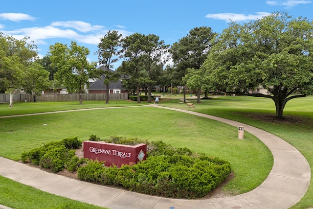 view of community with a lawn and fence