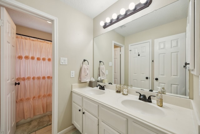 full bathroom with double vanity, a sink, a shower with shower curtain, and tile patterned floors