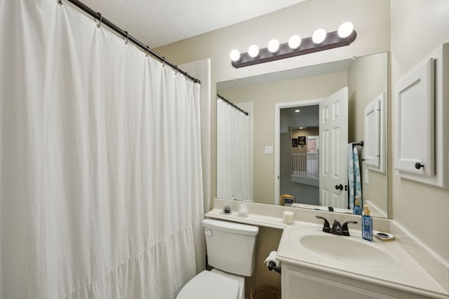 bathroom featuring vanity, a textured ceiling, and toilet