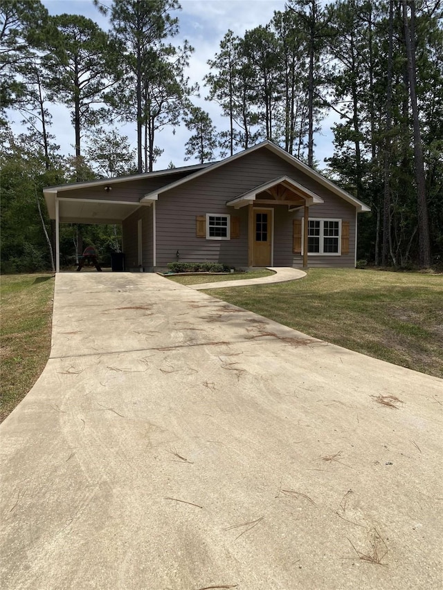view of front facade with an attached carport, concrete driveway, and a front yard