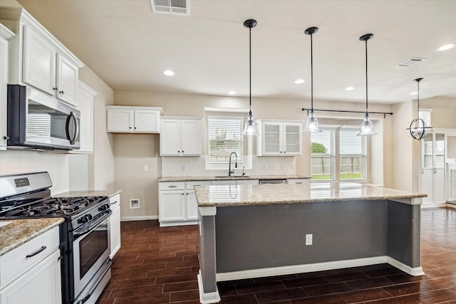 kitchen featuring visible vents, a sink, appliances with stainless steel finishes, and wood finish floors