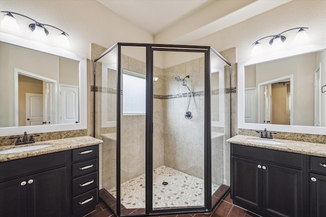 bathroom featuring a sink, two vanities, and a shower stall
