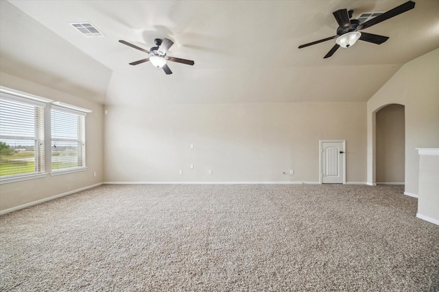 carpeted empty room with arched walkways, a ceiling fan, baseboards, lofted ceiling, and visible vents