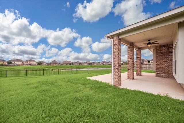 view of yard featuring a patio, a residential view, a ceiling fan, and a fenced backyard