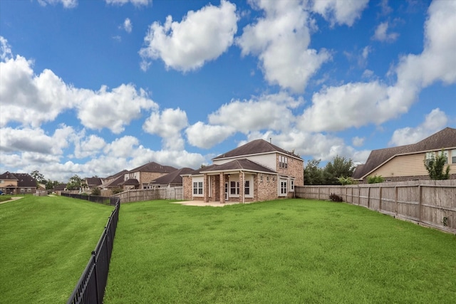 rear view of house featuring brick siding, a patio, a fenced backyard, and a lawn