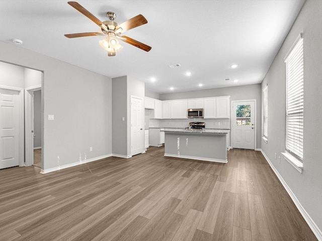 kitchen featuring ceiling fan, stainless steel appliances, white cabinetry, wood finished floors, and visible vents