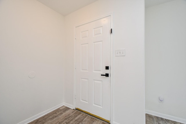 doorway with baseboards and wood finished floors